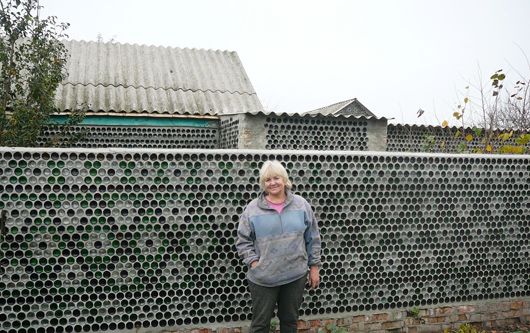Жителька Полтавщини зробила собі паркан із 50 тисяч скляних пляшок