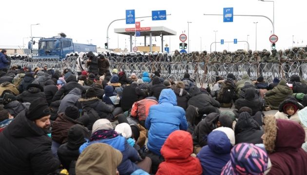 Мігранти залишають табір біля КПП на кордоні з Польщею у супроводі білоруських військових