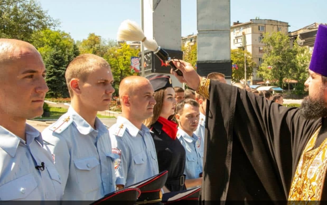 Негідники поліцейські-колаборанти освячуються московським попом у Маріуполі.