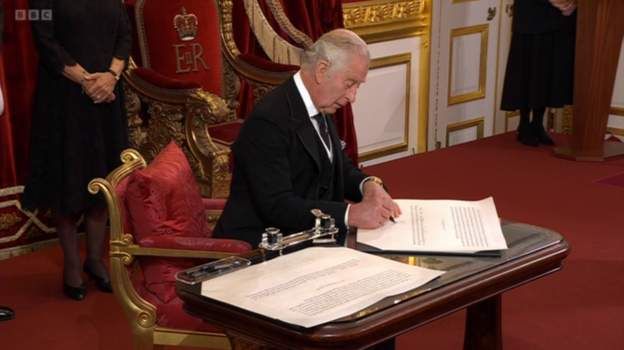 Король підписує присягу, яку щойно проголосив перед Таємною радою. Тепер свідки додають свої підписи під документом.