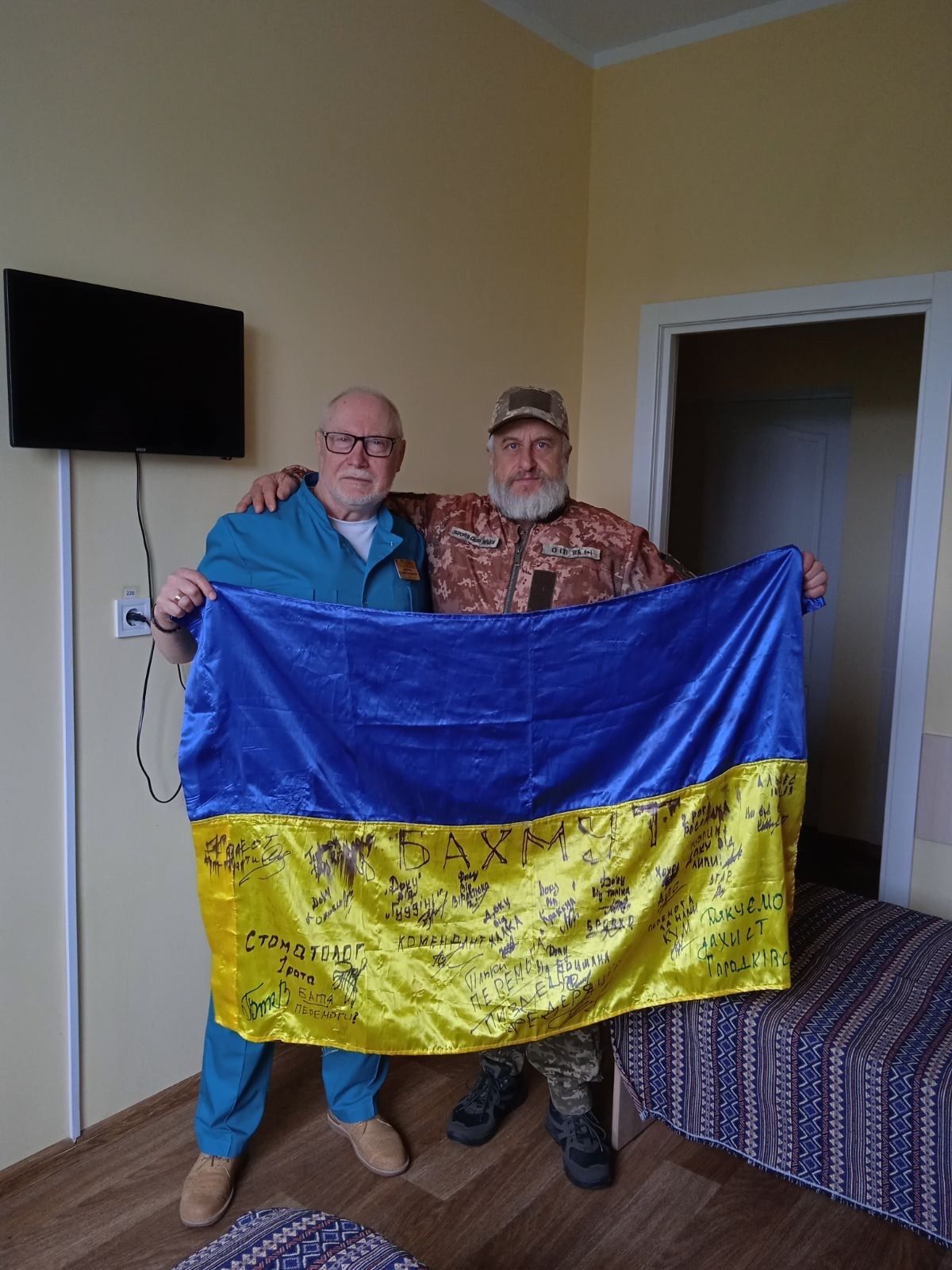 Завідувач відділення КМКЛ №8  Сергій Вєтров і захисник України  Сергій Горлей із бойовим прапором.