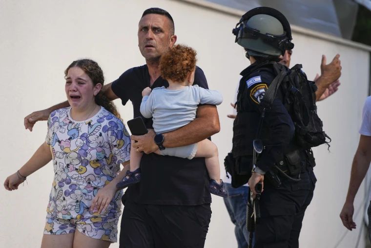 Ізраїльська поліція евакуює цивільних під час масованої атаки терористів.