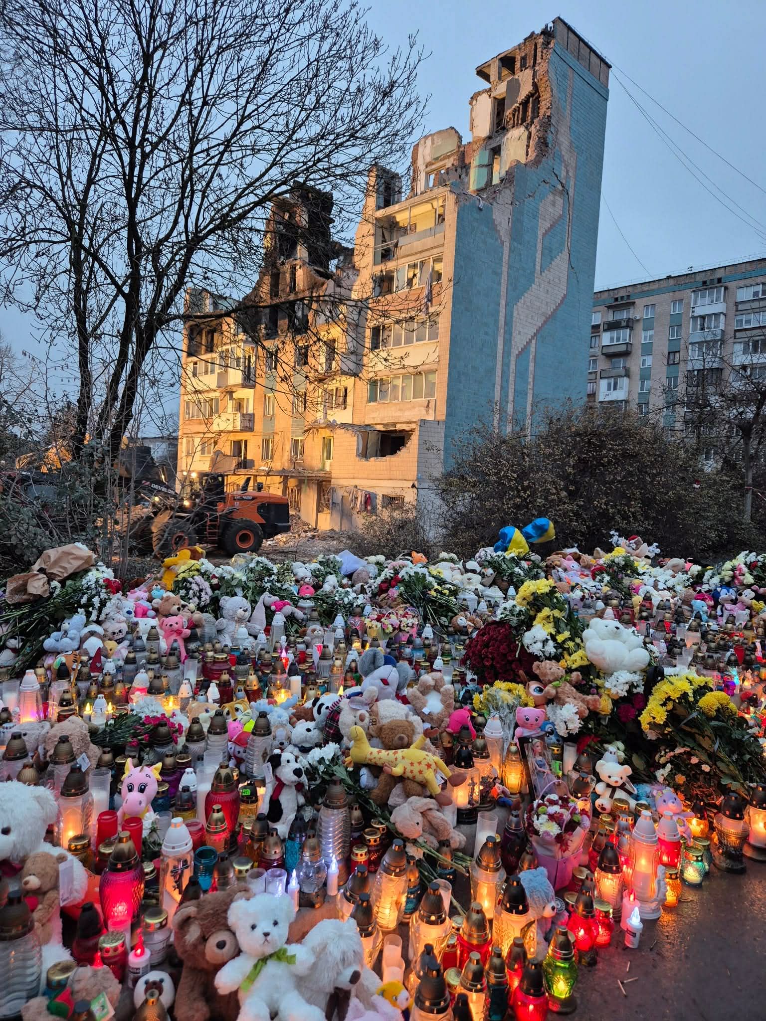 Люди продовжують нести до зруйнованого будинку  іграшки і запалювати свічки...